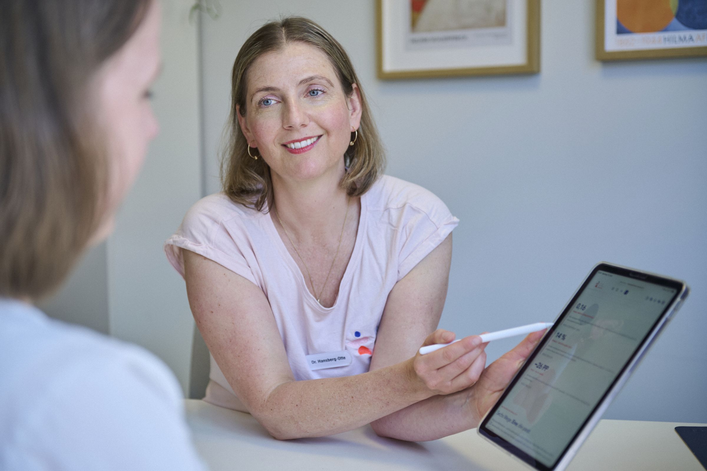 Dr. Marion Hansberg-Otte erklärt einer Patientin etwas am Tablet
